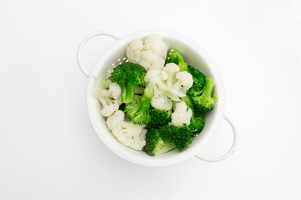 Cauliflower and broccoli florets in a colander