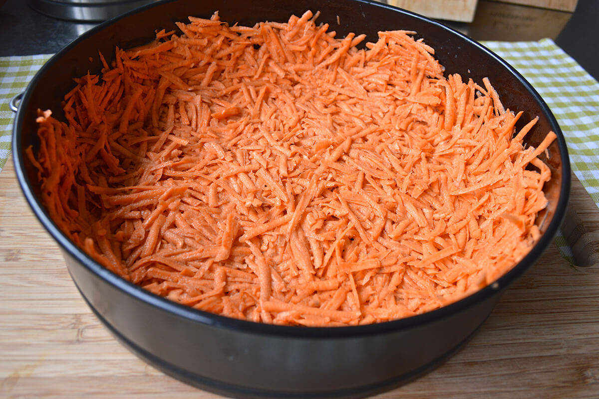 A tart tin with sweet potato crust mix in it