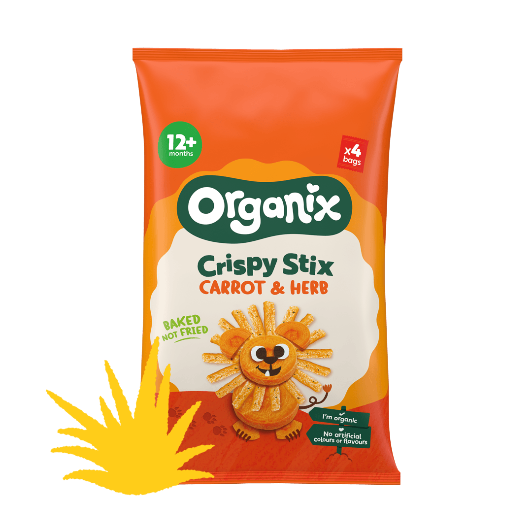 A rectangular yellow and orange pack of Organix Crispy carrot and herb sticks, cartoon lion made from carrot slices and the carrot and herb sticks is on the front. There is a yellow illustrated bush on the left hand side of the box.